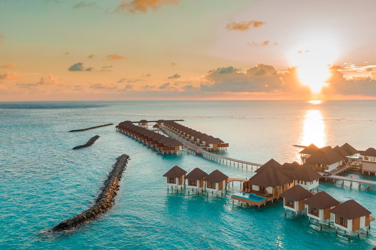 A breathtaking view of luxurious overwater villas in the Maldives at sunset.